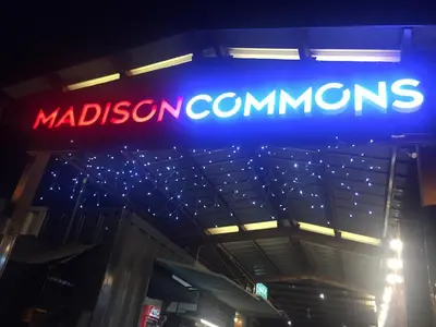 a neon sign for madison commissaries on a building at Ortigas Budget Hotel - Kapitolyo in Manila