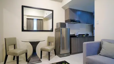 a kitchen with a table and chairs and a mirror at Currency Serviced Suites in Manila