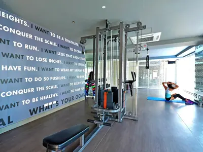 a woman is working out in a gym at Currency Serviced Suites in Manila