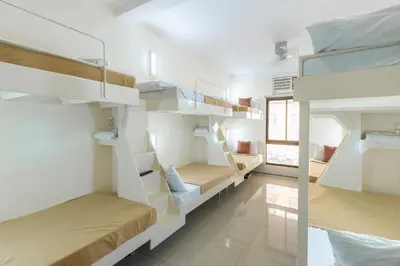 a room with two bunk beds and a window at Selah Garden Hotel Manila in Manila