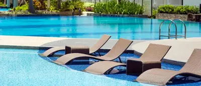 a group of chairs sitting next to a swimming pool at 1Bedroom with Balcony in Manila