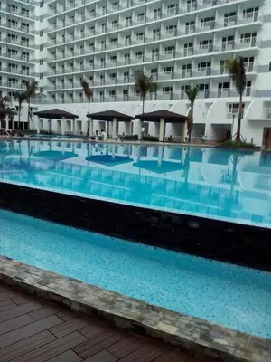 a large swimming pool in front of a hotel at 1Bedroom with Balcony in Manila