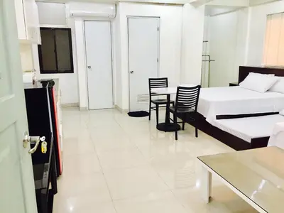 a room with two beds and a table and chairs at RESIDENCIA SAN VICENTE - PASAY -Budget Hotel in Manila
