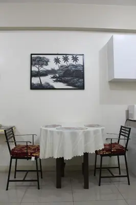 a table with two chairs and a picture on a wall at RESIDENCIA SAN VICENTE - PASAY -Budget Hotel in Manila