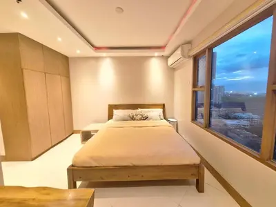 a bedroom with a bed and a large window at MANILA BAYVIEW RENTAL- LUXURY AND SUPERIOR 1 - 5 BEDROOM CONDOS WITH BALCONY POOL BAYVIEWS NETFLIX - Housekeeping Available- in Manila