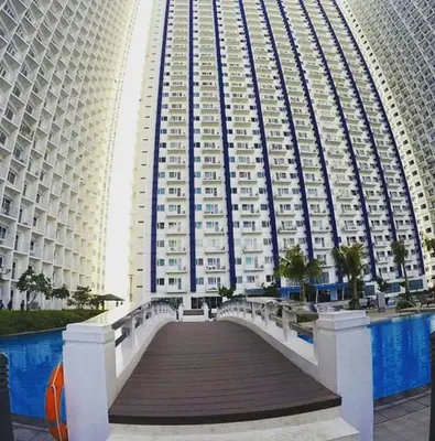 a large building with a bridge in front of it at Linda's Condo in Manila