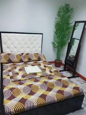 a bed with a blanket on it with a laptop on it at N&J Lopez Lodging House in Manila