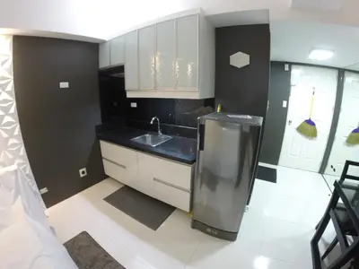 a small kitchen with a sink and a counter at Burgundy McKinley Place Service Apartment in Manila