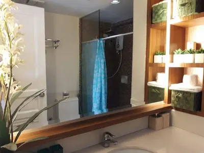 a bathroom with a shower with a blue shower curtain at Sorrel Residences Condo Apartment by Fe in Manila
