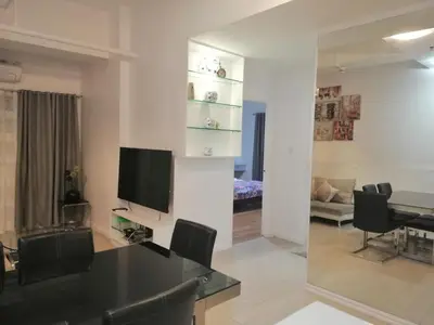 a living room with a table and a dining room at Luxury spacious 2BR in Salcedo Village in Manila