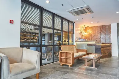 a lobby with two chairs and a table and a bar at 5880 Enriquez Residences in Manila