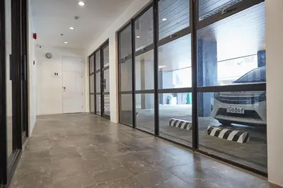 a hallway with large windows and a car parked in a garage at 5880 Enriquez Residences in Manila
