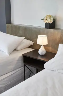 two beds with a table with a lamp on it at 5880 Enriquez Residences in Manila
