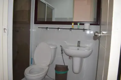 a bathroom with a toilet and a sink and a mirror at Affordable Makati APT in Manila