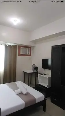 a bedroom with a bed and a desk and a television at Affordable Makati Serviced Apartments in Manila