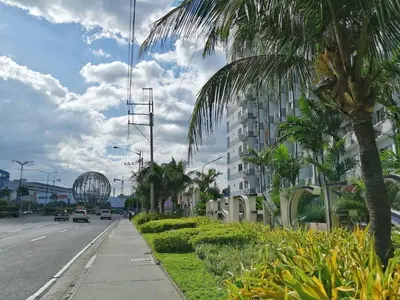 a street with a palm tree and a building at Salem's Abode in Manila