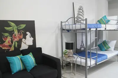 a living room with a couch and bunk beds at Food District Hostel - Ortigas Kapitolyo in Manila