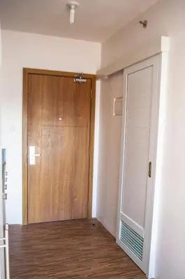 a door in a room with a wooden door at Titan Condo at Studio City Tower 1 Alabang in Manila
