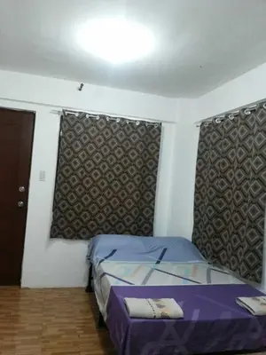 a bedroom with a bed in a room with a window at Budget Studio Unit in Makati in Manila