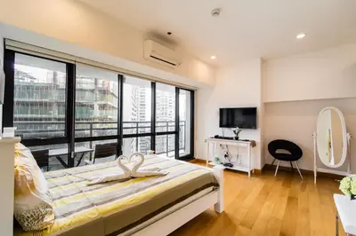 a bedroom with a bed and a large window at 1BR Milano Residences by Versace in Manila