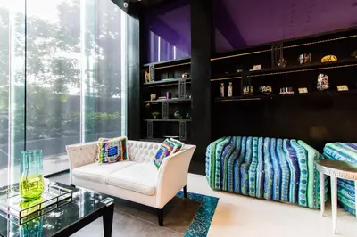 a living room with a white chair and a glass table at 1BR Milano Residences by Versace in Manila