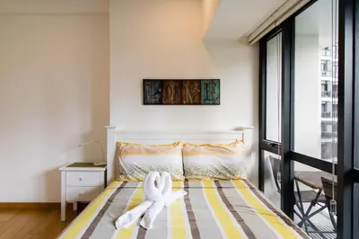 a bedroom with a bed with two white towels on it at 1BR Milano Residences by Versace in Manila