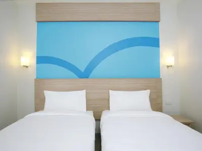 two beds sitting next to each other in a room at Hop Inn Hotel Makati Avenue Manila in Manila