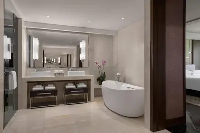 a bathroom with a tub and two sinks and a mirror at Manila Marriott Hotel at Newport World Resorts in Manila