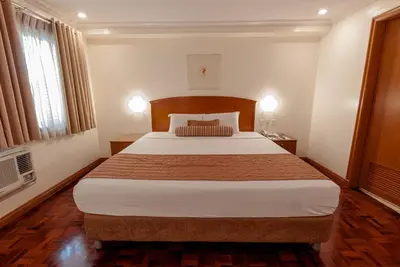 a bedroom with a large bed in a room at City Garden Suites Manila in Manila