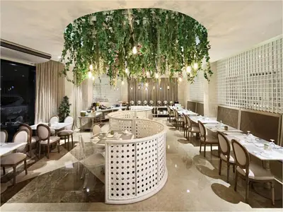 a restaurant with tables and chairs and a chandelier at Manila Lotus Hotel in Manila