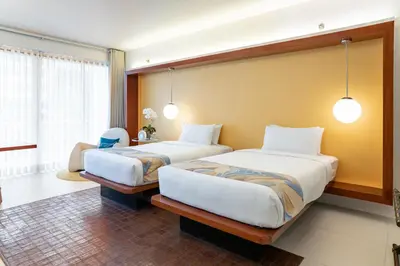 a bedroom with two beds and a chair at The Picasso Boutique Serviced Residences Managed by HII in Manila