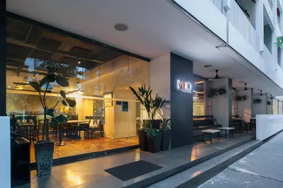 a restaurant with tables and chairs in a building at The Picasso Boutique Serviced Residences Managed by HII in Manila