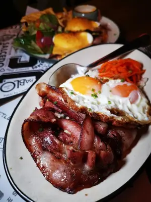 a plate of breakfast food with eggs and bacon at The Picasso Boutique Serviced Residences Managed by HII in Manila