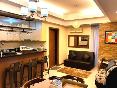 a living room with a couch and a bar at Luckycat Homestay in Manila