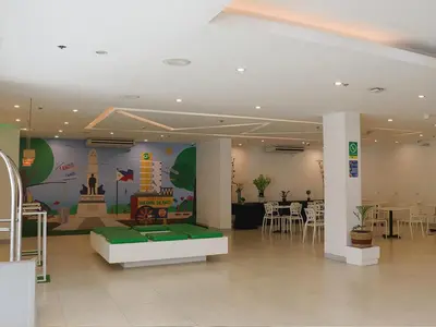 a restaurant with a table and chairs and a room at Go Hotels Ermita, Manila in Manila