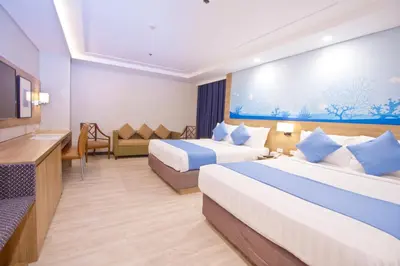 a hotel room with two beds and a television at Crown Regency Hotel Makati in Manila