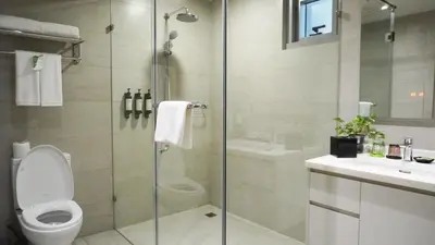 a bathroom with a shower and a toilet and a sink at Citadines Millennium Ortigas Manila in Manila