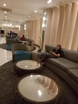 a woman sitting on a couch in a living room at Chin's Place Sea Residences MOA in Manila