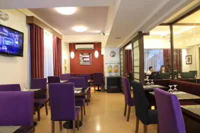 a dining room with purple chairs and tables at The Malayan Plaza Hotel in Manila