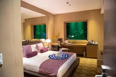 a bedroom with a bed and a desk in a room at Hotel H2O in Manila