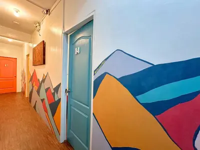 a hallway with a door with a painting on the wall at Dormitelsph España in Manila