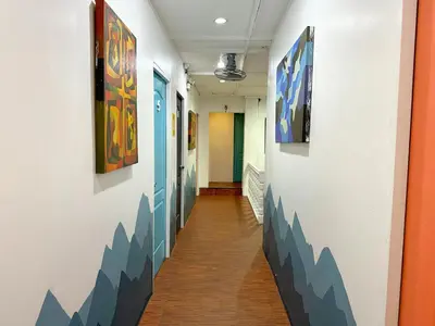 a hallway with paintings on the walls of a building at Dormitelsph España in Manila