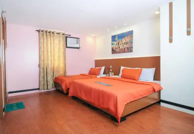 a bedroom with two beds with orange sheets at Eurotel Pedro Gil in Manila