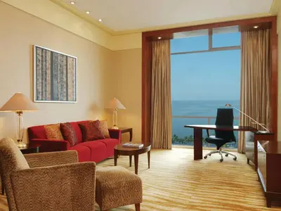 a living room with a red couch and a table at New Coast Hotel Manila in Manila