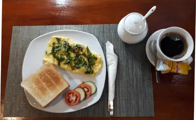 a white plate with breakfast food and a cup of coffee at Spaces Hotel Makati in Manila