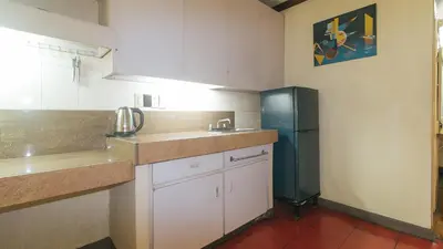 a kitchen with a refrigerator and a sink at RedDoorz at Broadway Court Apartelle Quezon City in Manila