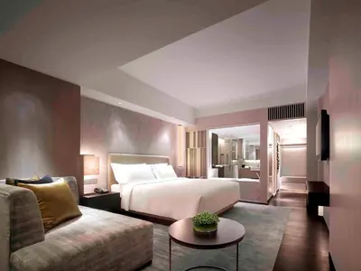 a hotel room with a bed and a couch at New World Makati Hotel, Manila in Manila