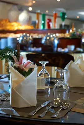a table with utensils on a table in a restaurant at Berjaya Makati Hotel in Manila