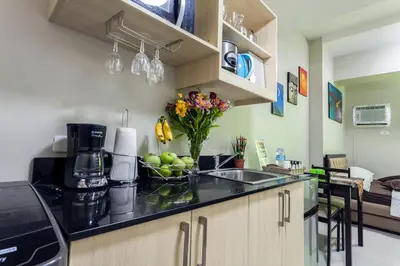 a kitchen with a sink and a counter with fruit on it at Yong's Place at Vista Residences Taft in Manila