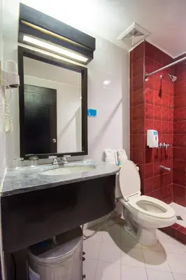 a bathroom with a sink and a toilet and a mirror at Microtel by Wyndham Eagle Ridge in General Trias